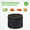 Black grow bag with handles filled with soil, showing various plants like lettuce, tomatoes, carrots, and beans.