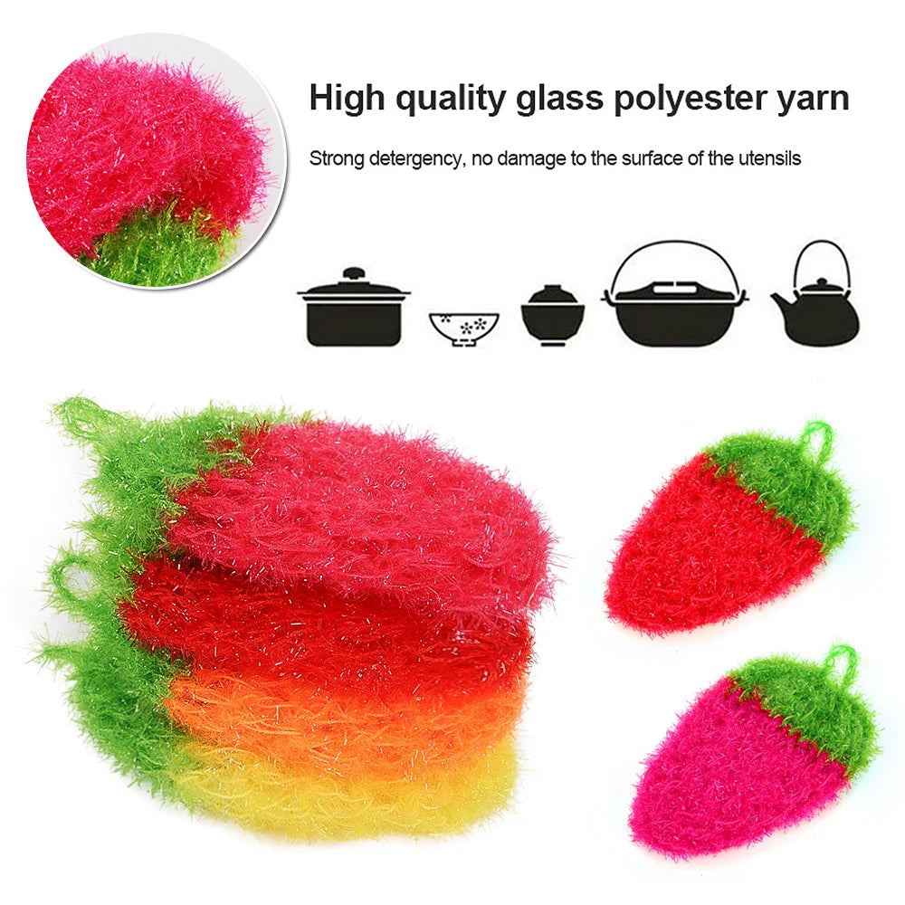 A variety of colored glass polyester yarn fibers shown next to a strawberry-shaped scrubber sponge.