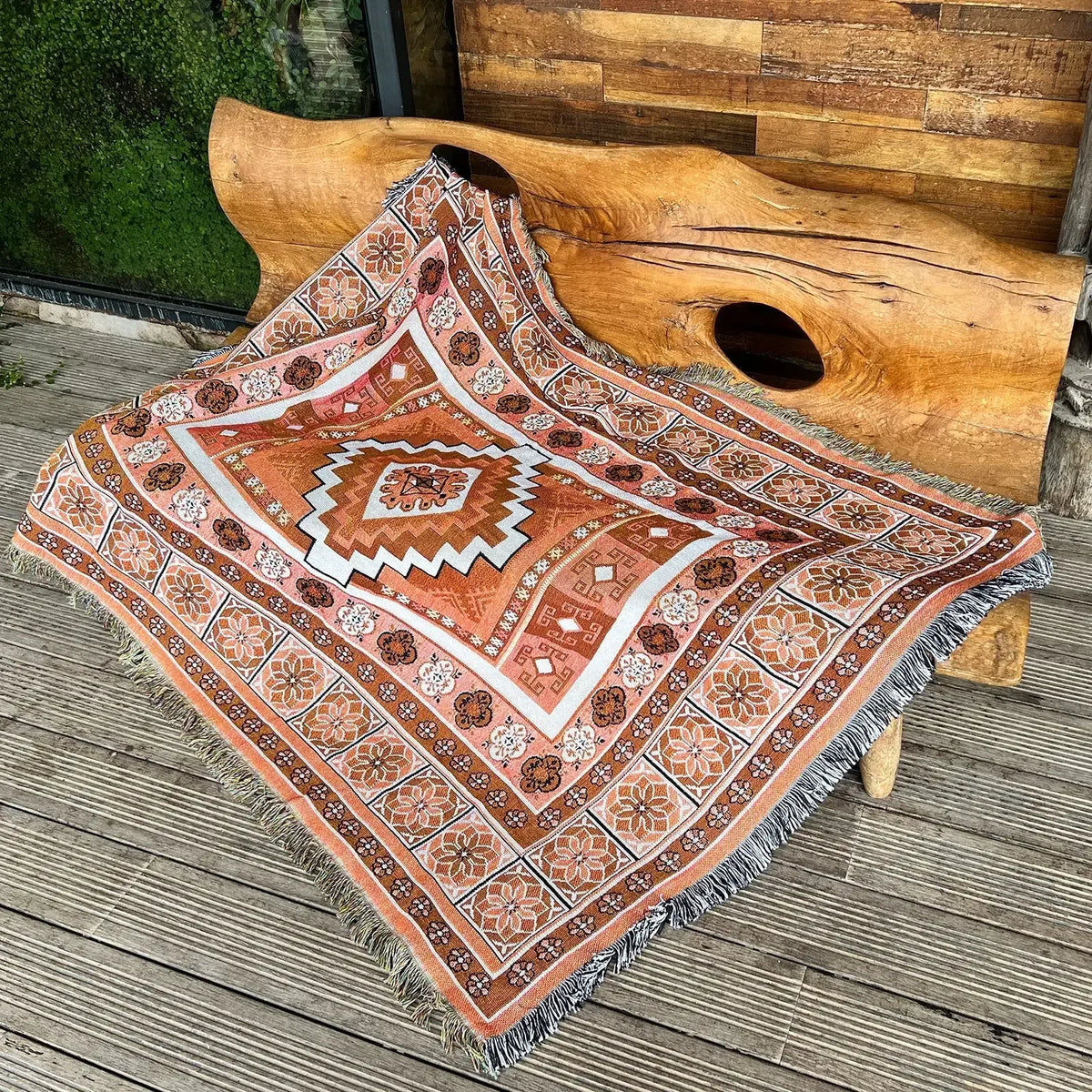 A patterned bohemian jacquard woven throw blanket with geometric designs is displayed on a wooden surface next to a large pie