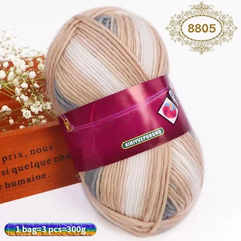 A ball of gradient dyed wool blend yarn with pink and beige tones, packaged for knitting.