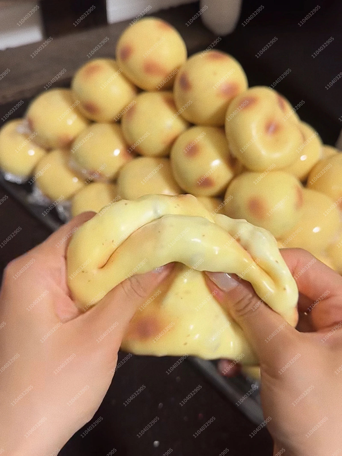 Eine Hand drückt einen gelben, runden Kartoffel-Stressball-Fidget-Spielzeug, umgeben von vielen ähnlichen Bällen.
