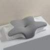 A gray ergonomic memory foam cervical pillow resting on a white surface.