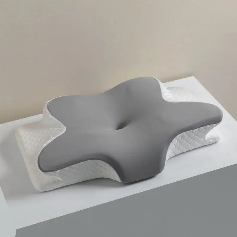 A gray ergonomic memory foam cervical pillow resting on a white surface.