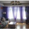 Purple sheer voile curtains hanging in a window with light filtering through.