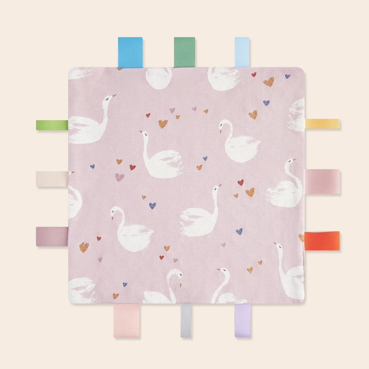 A pink baby sensory tag comfort blanket featuring white flamingos and hearts.