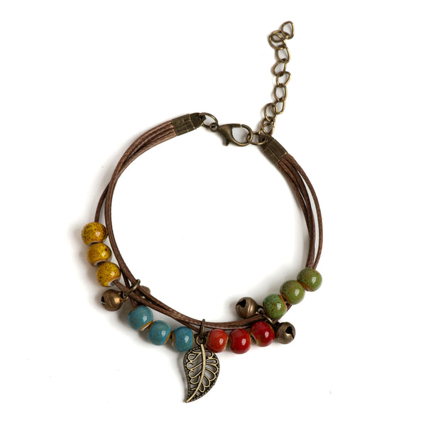 Adjustable ceramic bead bracelet with various colored beads and a leaf pendant on a leather cord.
