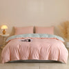 A pink quilted duvet cover set with matching pillowcases displayed on a bed.