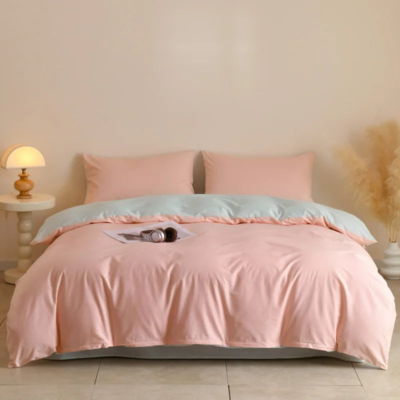 A pink quilted duvet cover set with matching pillowcases displayed on a bed.