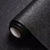 Roll of black textured self-adhesive wallpaper with visible crackle effects