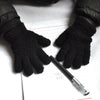 A pair of black fuzzy winter gloves resting on a piece of lined paper.