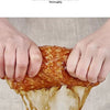 Hands are squeezing a piece of orange food, demonstrating the strong water absorption of a coral fleece material.