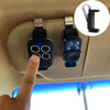 A close-up view of a black garage door remote clip holder mounted on a vehicle's interior panel.