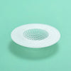 A white silicone sink drain filter strainer with a perforated design is shown against a light green background.