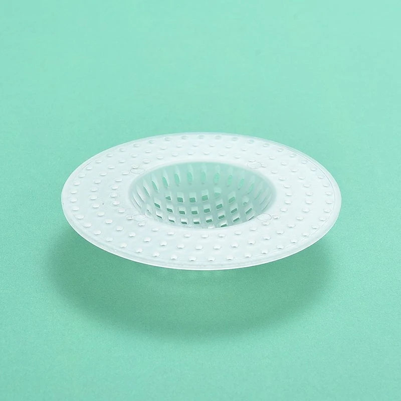 A white silicone sink drain filter strainer with a perforated design is shown against a light green background.