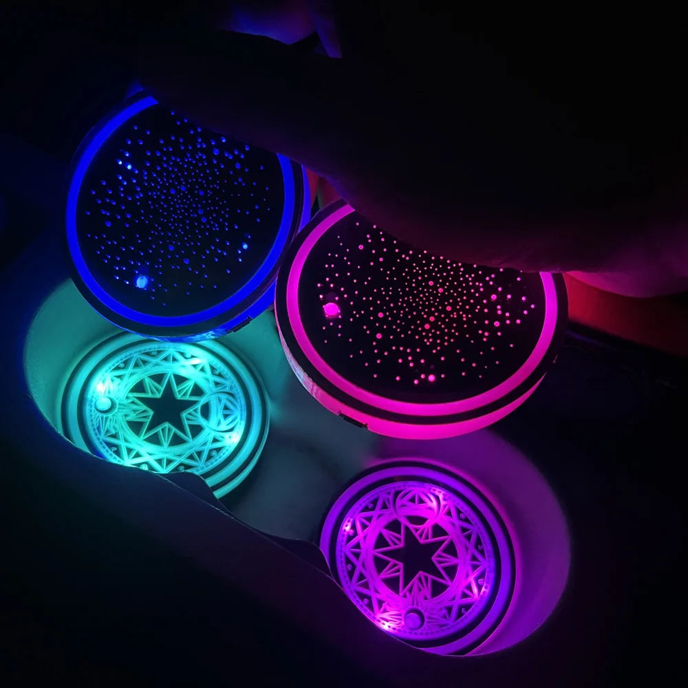 A hand is illuminating various colors of LED cup holder lights inside a car interior.