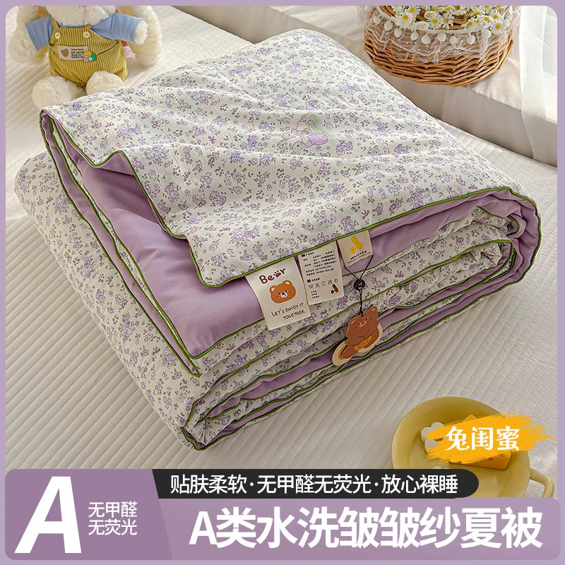 A washable quilt with a playful cartoon print featuring purple and green tones.
