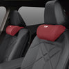 A close-up view of a black car seat with a red memory foam headrest neck pillow installed.