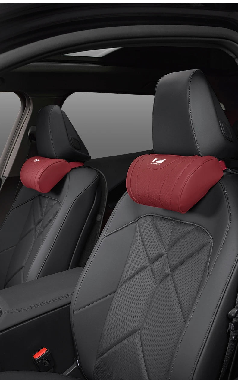 A close-up view of a black car seat with a red memory foam headrest neck pillow installed.