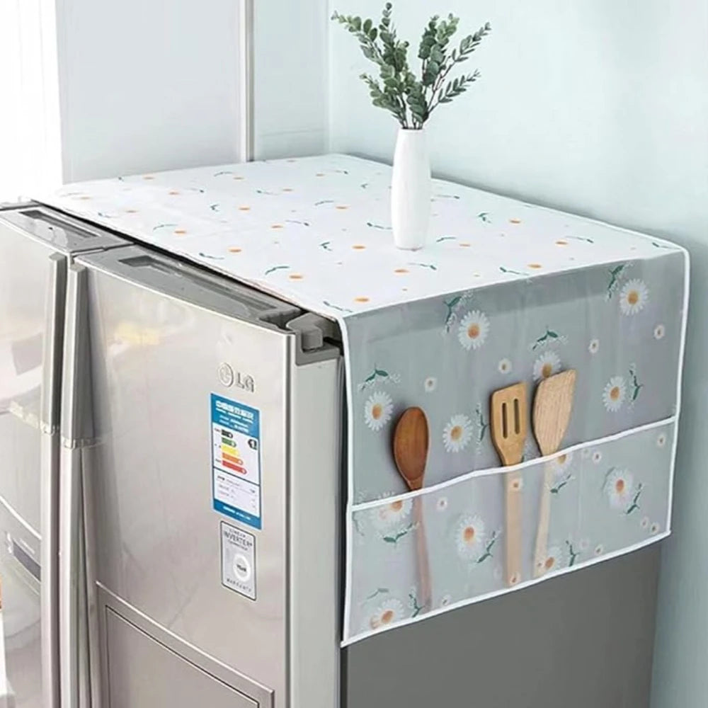 A refrigerator dust cover with storage pockets is displayed on a countertop, featuring a white and green floral pattern.