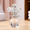 A clear crystal sculpture featuring a bouquet of translucent, reflective rose-like flowers atop a spherical base.