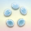Five handcrafted ceramic fish beads in varying shades of light blue arranged in a star pattern.