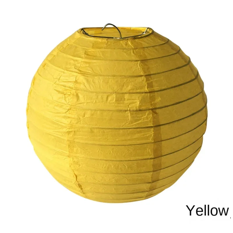 A round yellow paper lantern with a black hanger.