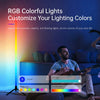 A man is sitting on a couch with an LED RGB floor lamp casting colorful ambient light onto the room.