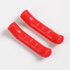 A pair of red silicone bicycle brake lever covers lying on a white background.
