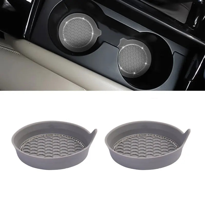 Two gray silicone coasters with a textured surface and rhinestone detailing for car cup holders