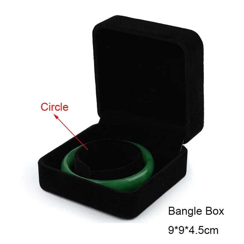 Black velvet bangle box with a green bangle inside