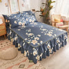 Jupe de lit bleu marine imprimée à motifs floraux blancs sur un lit.