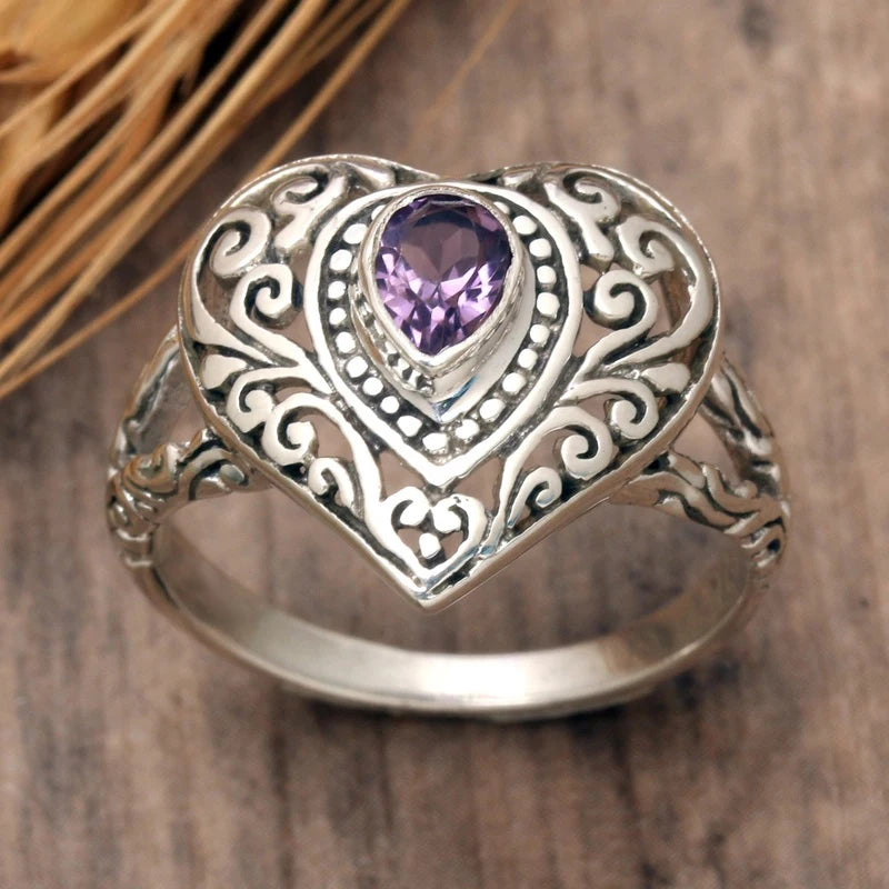 Silver vintage heart ring featuring a purple cubic zirconia gemstone set in an ornate design.