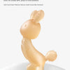A soft, light beige silicone cartoon rabbit teether for babies resting on a white surface.