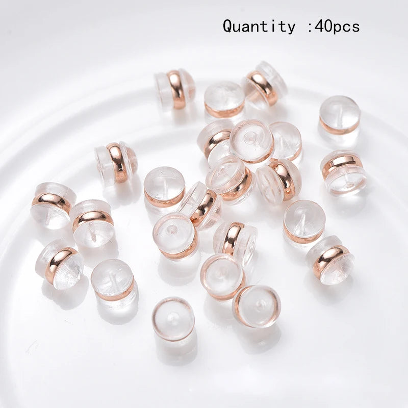 40 pieces of silicone rubber ear back stoppers with copper rings arranged on a white surface.