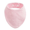 A pink organic cotton muslin baby bib with an absorbent bandanna and a padded band.