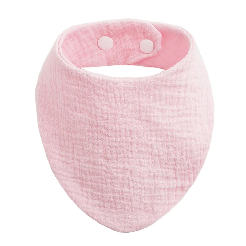 A pink organic cotton muslin baby bib with an absorbent bandanna and a padded band.