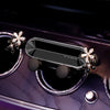 A crystal flower gravity car phone holder with auto-lock displayed on a purple surface.