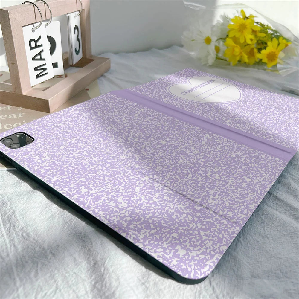 A purple composition notebook iPad case with a pencil holder is shown on a white sheet.