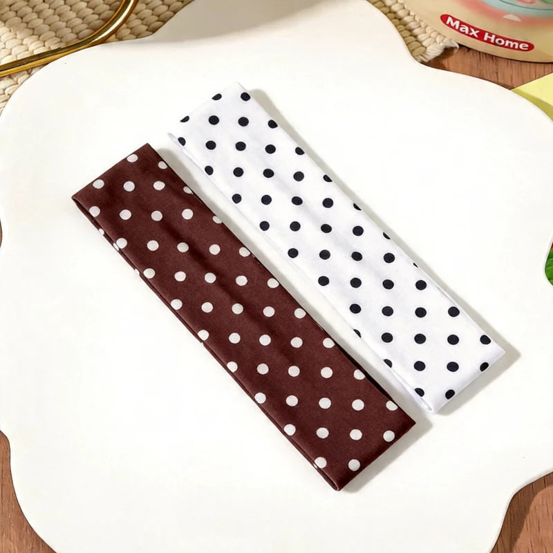 Un bandeau en tissu à pois marron et un bandeau en tissu à pois blanc sont présentés sur une surface blanche.