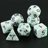 A set of seven polyhedral dice, including d4s, d6s, and d8s, scattered on a dark surface.