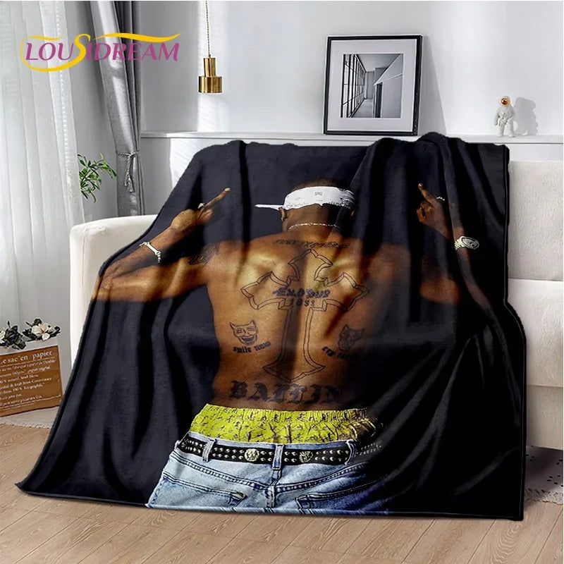 A black throw blanket featuring a graphic design of an artist's back with tattoos and gold chains.