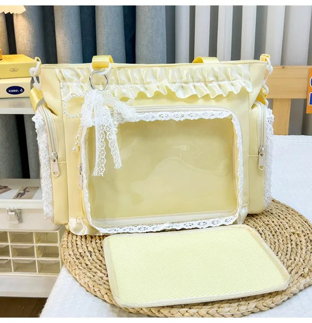 A yellow transparent shoulder bag with white lace trim resting on a woven mat.
