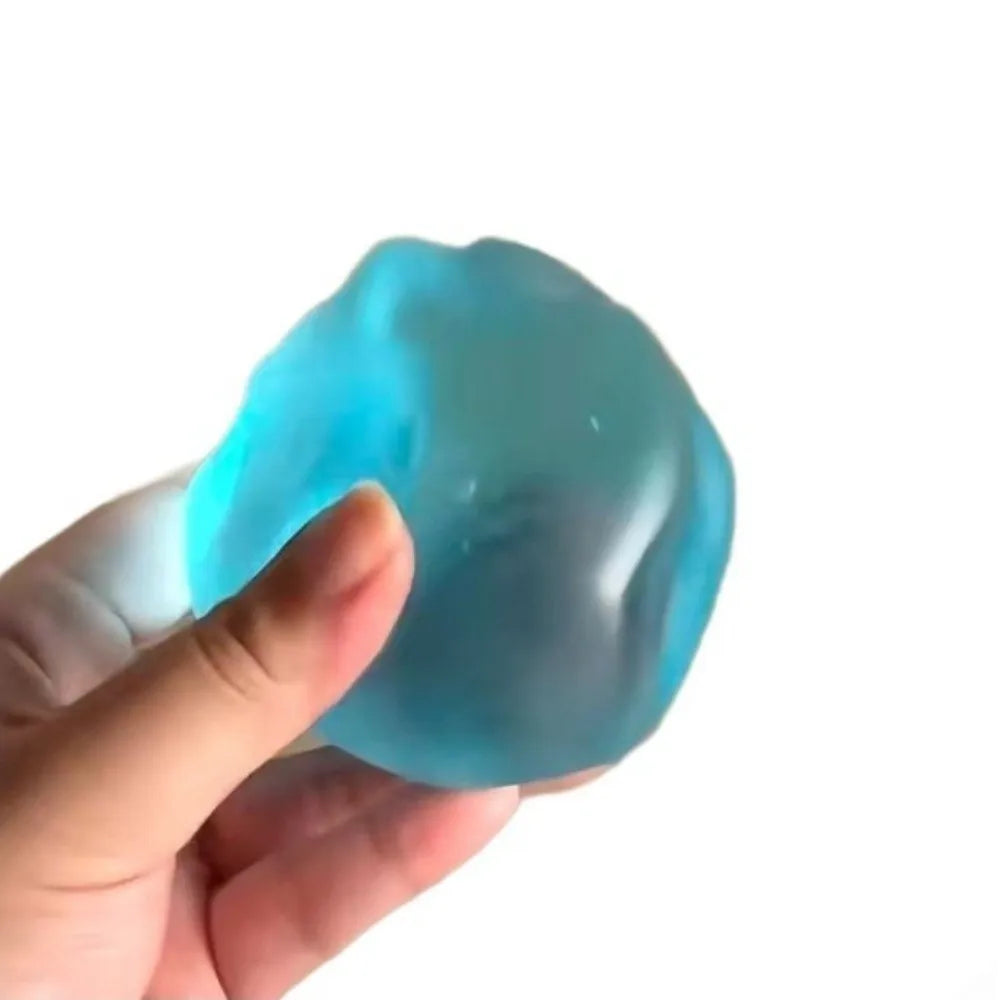 A hand is holding a translucent blue slow-rise stress ball.