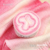 Pink and white gradient cake yarn rolled up on a pink fabric background