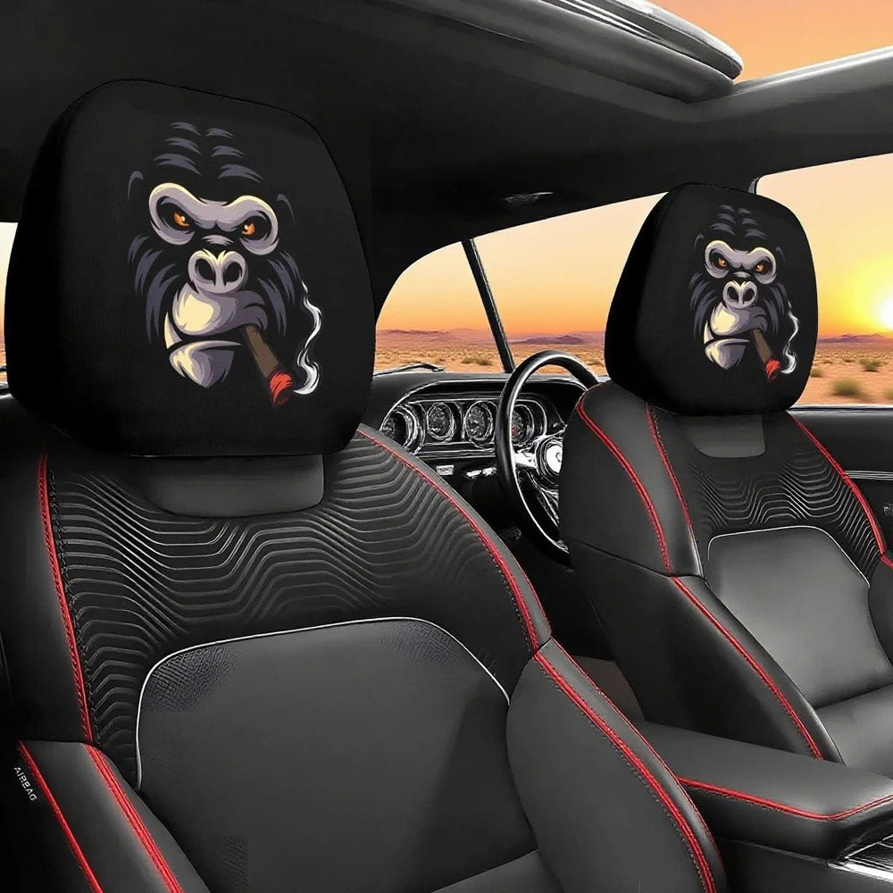 Two black car headrest covers featuring stylized monkey eyes are shown in a vehicle interior.