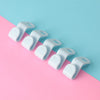 White space-saving cascading hanger connector hooks arranged diagonally on a pink and blue background.