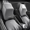 A close-up view of a gray memory foam car headrest and lumbar support pillow designed for comfort.