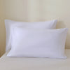 A set of three white premium brushed fabric pillow covers resting on a white surface.