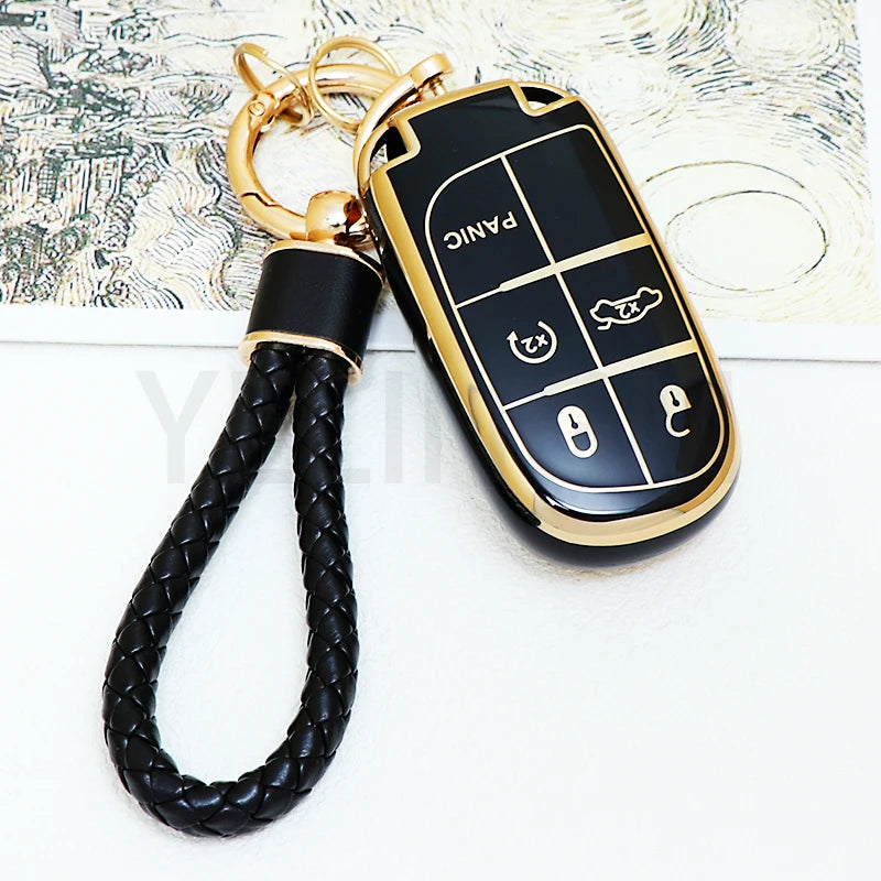 A black and gold durable TPU car key fob cover with various function buttons attached to a black braided leather strap.