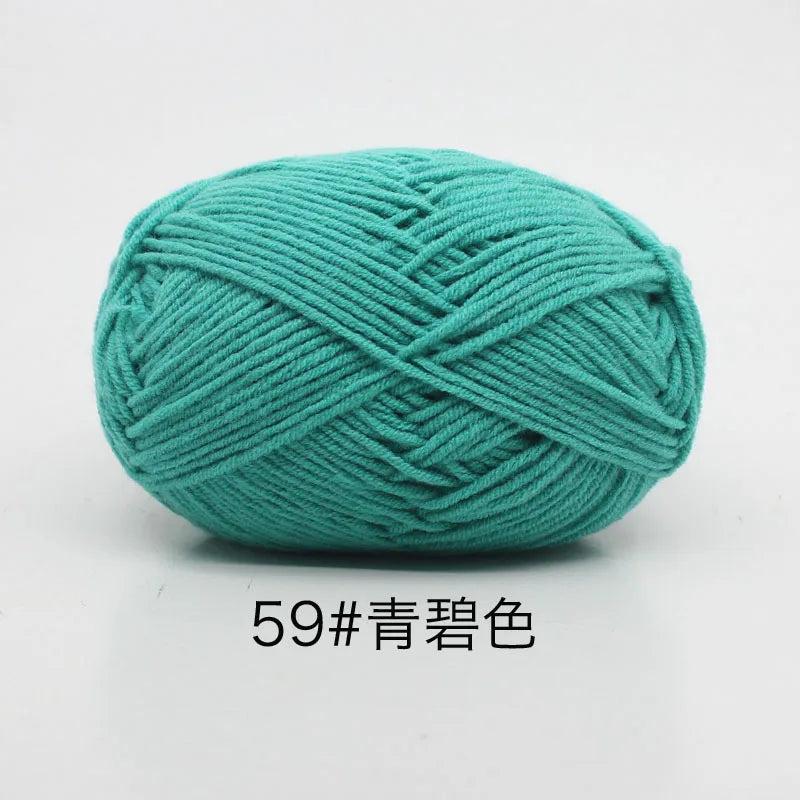 A ball of teal colored 4-ply milk cotton yarn for knitting and crochet.